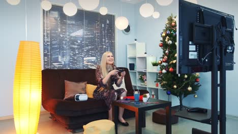 Young-lady-playing-on-playstation-in-front-of-TV-at-New-Year's-Eve