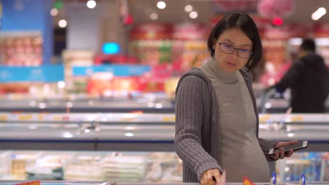 Schwangere-asiatische-Frau-einkaufen-im-Supermarkt