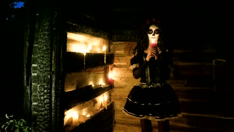 Young-woman-with-scary-skeleton-Halloween-make-up-holding-a-lighted-candle.-HD