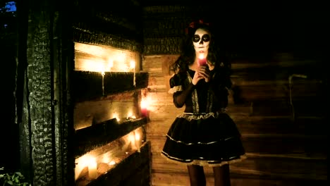 Young-woman-with-scary-skeleton-Halloween-make-up-holding-a-lighted-candle.-HD