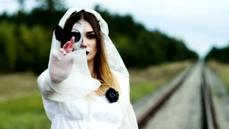 Un-retrato-de-mujer-joven-con-maquillaje-espeluznante-para-Halloween-en-un-vestido-de-novia.-4K