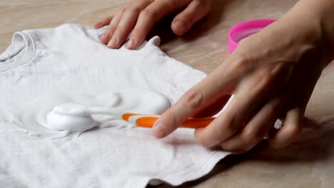 Mother-to-clean-stains-on-children's-clothes-from-candies-with-the-help-of-stain-remover-and-washing-powder,-close-up,-stain-removal,-hygiene