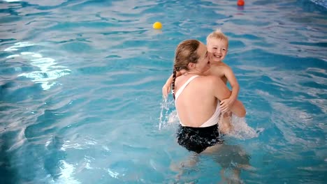 Schwimmbad.-Mama-bringt-einem-kleinen-Kind-das-Schwimmen-im-Pool-bei.