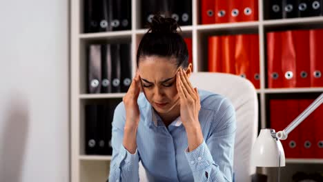 Portrait-of-tired-young-businesswoman-with-computer-in-office