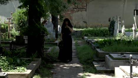 Grieved-widow-filled-with-sorrow-leaving-from-departed-husband-grave-walking-in-cemetery-alley