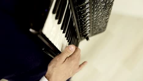 Close-up-of-a-man's-right-hand-playing-on-a-black-accordion.