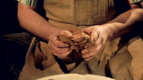 Strong-potters-hands-knead-a-piece-of-clay.