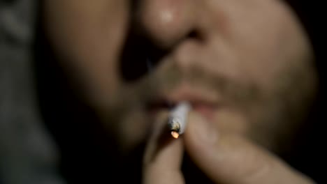 Extreme-close-up-of-man-smoking-marijuana-joint