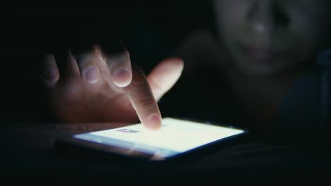 Woman-using-cellphone-in-bed-at-night