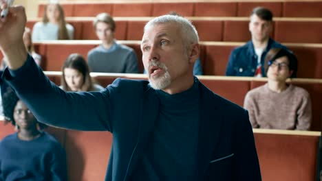 Camera-Facing-Class:--Prominent-Professor-Writing-on-the-Blackboard-and-Giving-Lecture-to-a-Class-of-Multi-Ethnic-Students.-Modern-University-with-Bright-Young-People-in-the-Lecture-Hall.