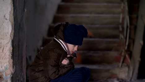 frozen-wary-boy-is-warming-in-a-dilapidated-old-house