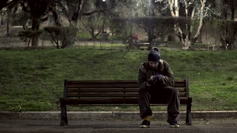 hungrige-Obdachlose-auf-Bank-nachts-sein-Geld-zählen