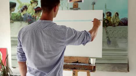 man-painter-paints-picture-on-blank-canvas