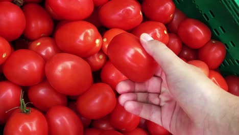 Hand-eines-Mannes-Kommissionierung-frische-Tomaten-im-Supermarkt