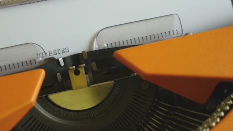 Close-up-footage-of-a-person-writing-DIABETES-on-an-old-typewriter