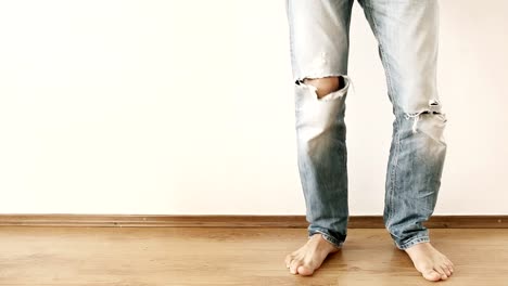 Dancing-legs-in-torn-jeans-against-the-white-wall