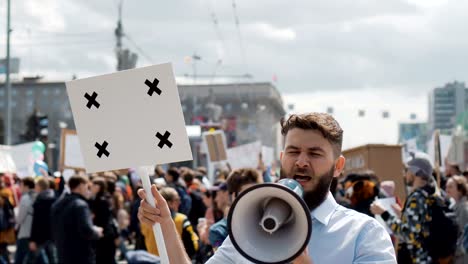 European-people-at-demonstration.-Man-with-a-banner-screaming-into-a-mouthpiece.