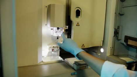 A-handheld-shot-of-a-researcher-checking-a-DNA-sequencer-a-genetic-laboratory-at-university