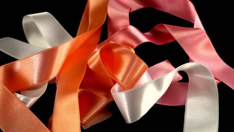 Satin-ribbon-on-a-black-background.-Slow-motion.