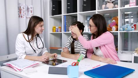 Examination-of-the-patient-in-the-office-of-child-adolescent-physician.-The-doctor-measures-the-temperature-of-a-teenage-girl-examination-in-medical-clinic.