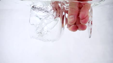 Ein-Mann-hält-einen-Becher-in-der-Hand-und-gießt-Wasser-hinein,-close-up-Slow-motion