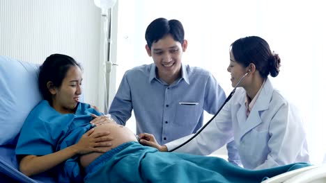 Female-doctor-visiting-to-pregnant-woman-at-hospital.-Pregnant-woman-and-he-husband-talking-to-doctor-with-happy-emotion.-People-with-healthcare-and-medical-concept.