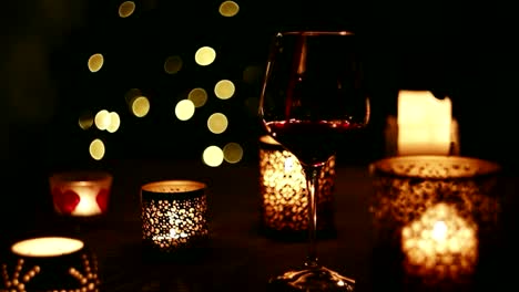 Wine-pouring-into-a-glass-on-the-background-of-Christmas-tree-in-the-evening-dark.-New-Year-holidays-beverage-concept-image.