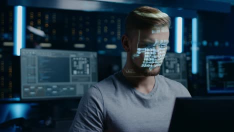 Portrait-of-Young-Software-Developer-Working-on-Computer-in-Digital-Identity-Cyber-Security-Data-Center,-Projected-Program-Coding-Language-Reflects-on-His-Face.-Futuristic-Hacking-and-Programming-Concept