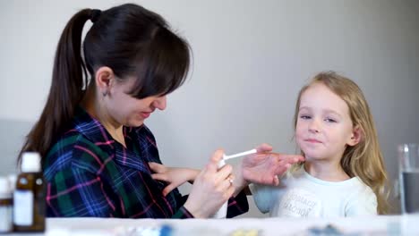 Madre-uso-medicina-spray-de-garganta-para-niña