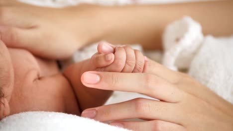 Neugeborene,-die-Mutter-die-Hand-halten,-in-der-Nahaufnahme