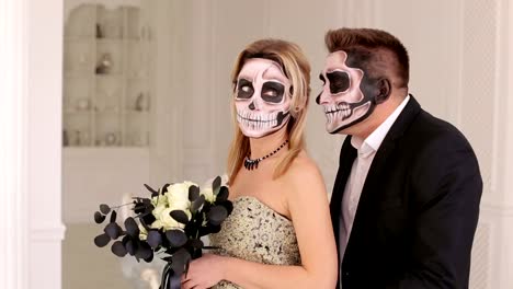 Halloween-couple,-woman-and-man-with-skull-make-up.-Halloween-face-art.