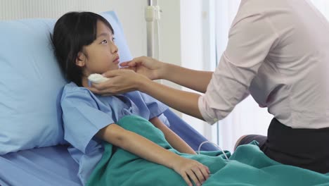 Asiatische-Mutter-reiben-den-Körper-Patient-kleines-Mädchen-für-die-Temperatur-und-körperliche-Untersuchung-im-Krankenhaus-zu-reduzieren.-Konzept-der-Familie,-Medizin,-Gesundheitswesen-und-Technologie.