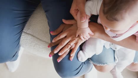 Madre-con-hija-y-nieta-de-familia-multigeneracional-comparando-tamaños-de-manos