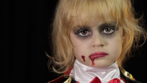 Dracula-child.-Girl-with-halloween-make-up.-Vampire-kid-with-blood-on-her-face