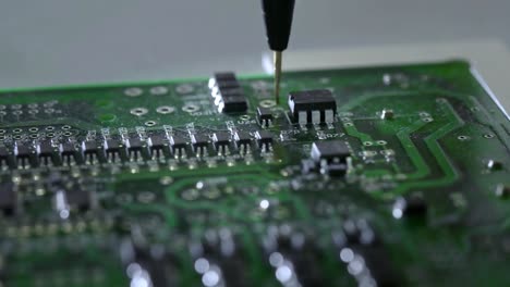 Mechanical-creation-process-of-electronic-circuits.-Creating-an-electronic-board.-Metal-needle-sets-the-chips-on-a-plastic-backing.-Solders-electronic-components.