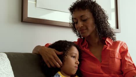 Front-view-of-African-american-mother-consoling-her-son-in-the-lobby-at-hospital-4k