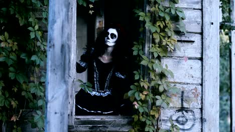 A-young-woman-with-spooky-skeleton-Halloween-make-up-looking-out-the-window.-4K