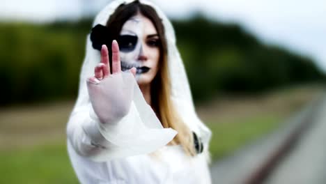 The-young-woman-with-spooky-make-up-for-Halloween-in-a-white-bride-dress.-4K