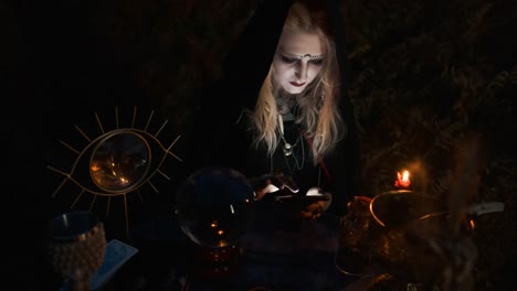 Halloween.-Young-Witch-Spells-At-The-Table.