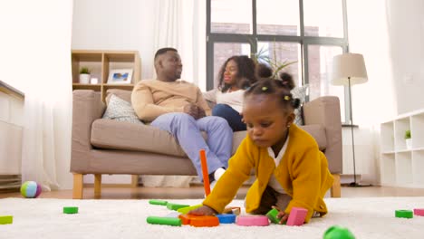 afrikanische-Baby-Mädchen-spielen-mit-Spielzeug-Blöcke-zu-Hause