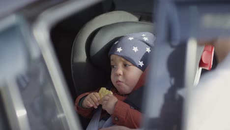 Madre-irreconocible-asegurando-a-los-niños-pequeños-en-el-asiento-del-coche