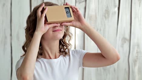 Young-curly-woman-using-Virtual-Reality-Glasses