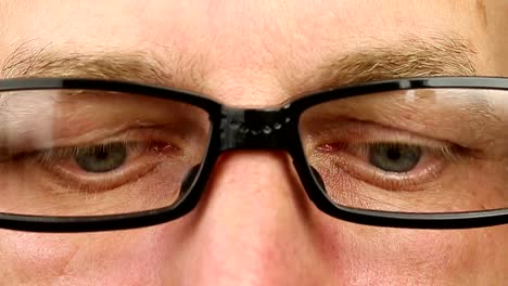 Caucasian-man-in-eyeglasses-extremely-close-up-view.-Thinking-looking-around.-Eye-movement-side-to-side.-Corner-of-eyes.-Smiling-laughing-man-face-glasses.-Think-read-see-down-up-and-side-eyes-motion