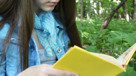 Retrato-de-linda-chica-adolescente-leyendo-el-libro-y-la-página-de-inflexión-apoyado-contra-el-tronco-de-árbol-en-el-bosque-en-primavera,-estudiar-al-aire-libre