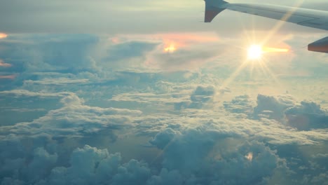 Vista-aérea-de-nubes-blancas-sobre-cielo-azul-en-la-salida-del-sol-con-el-reflejo-en-el-océano