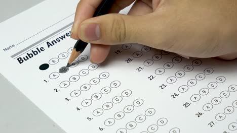 Asian-student-hand-doing-examination-test-with-standardized-test-form-and-answers-bubbled.