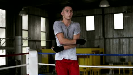 Handsome-young-caucasian-sportsman-is-jumping-with-a-skip-rope-while-working-out-in-boxing-gym,-doing-cross-moves-with-skipping-rope