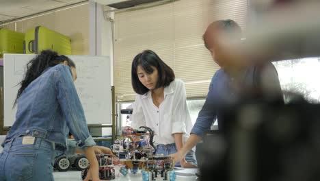 Team-of-electronics-engineer-working-together,-collaborating-on-a-project-to-build-robot.-People-with-technology-or-innovation-concept.