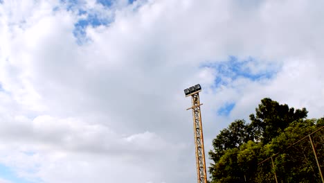 Electric-spotlight-pole-with-blue-sky-background,-time-lapse.