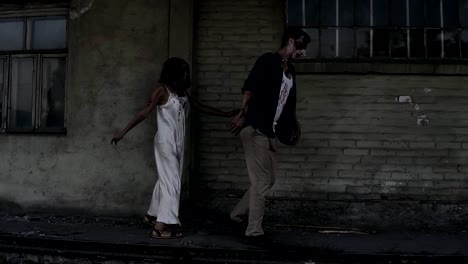 Concepto-de-horror-de-Halloween.-Foto-de-fantasma-espeluznante-de-macho-y-hembra-o-zombie-caminando-con-heridos-cara.-Una-vieja-casa-abandonada-en-el-fondo.-Vista-lateral